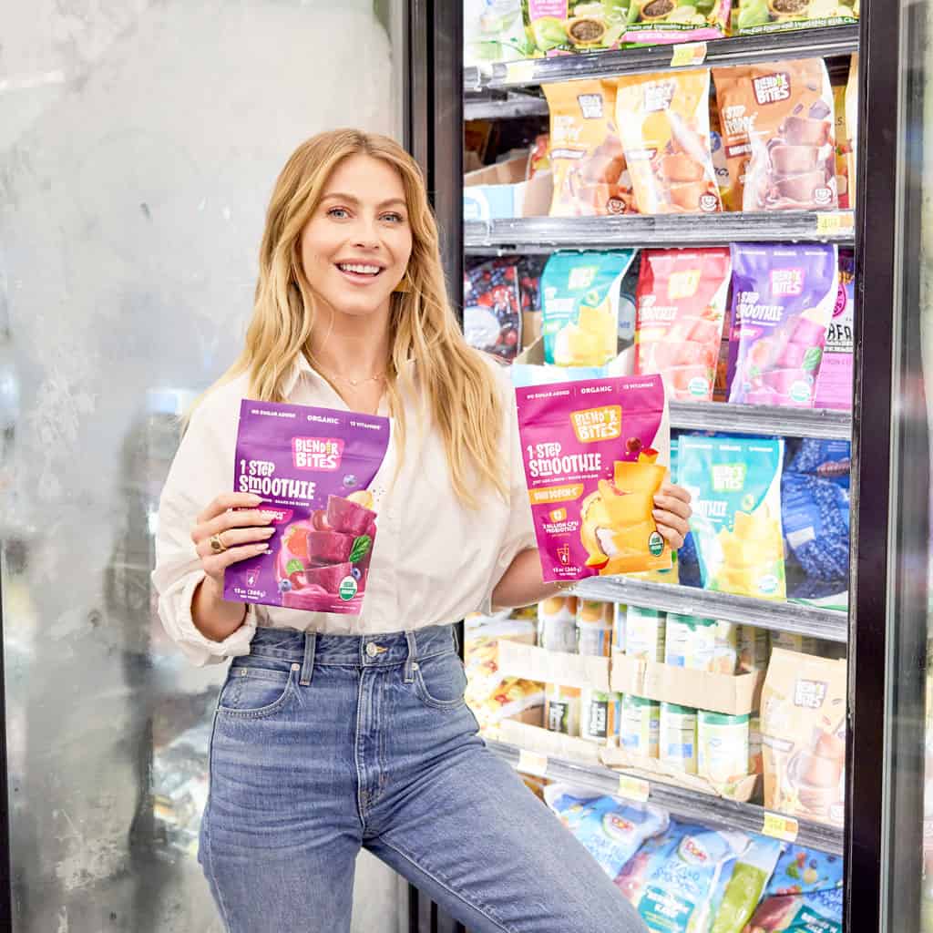 julianne-hough-holding-up-blender-bites-smoothie-pouches-in-front-of-walmart-freezer